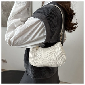 Dettaglio borsa a mezzaluna bianca effetto coccodrillo con zip dorata su modella