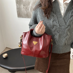Retro burgundy leather bucket bag with gold triangle plaque and slim shoulder strap