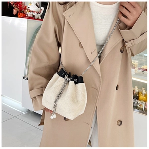 Détail du sac seau en peluche blanche avec perles de serrage et chaîne argentée