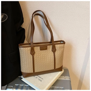 Detail of a woven tote bag with brown leather edges and Fashion & Bags Leather logo