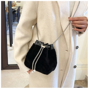Détail d'un sac seau en peluche avec chaîne argentée et perles blanches décoratives