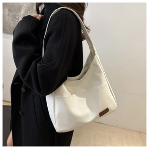 Vista dettagliata di una borsa hobo in pelle PU bianca con un inserto decorativo in cuoio