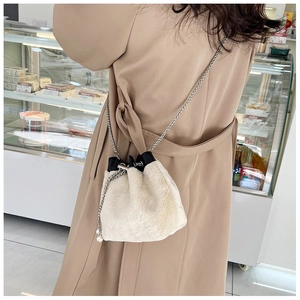 Sac seau en fausse fourrure blanche avec chaîne argentée et perle sur modèle