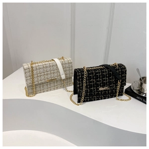 Detailed view of tweed crossbody bags with gold chain straps in beige and black colors