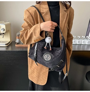 Détail d'un sac cabas en velours noir avec logo M et charm peluche blanc mignon