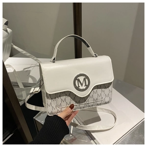Detail of white PU leather handbag with gold M logo and logo monogram pattern