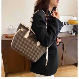 Woman in black suit carrying a large brown geometric tote bag with cream-colored handles