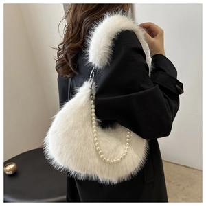 Détail du sac à épaule en fausse fourrure blanche avec chaîne de perles et texture hiver