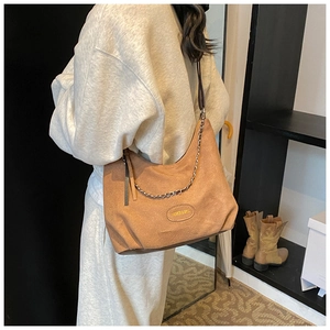 Dettaglio borsa hobo in camoscio marrone con catena argento e toppa Fashion & Bags