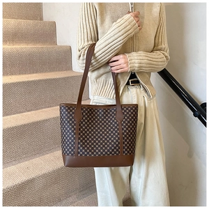 Macro detail of retro tote bag showing vintage geometric pattern and leather straps