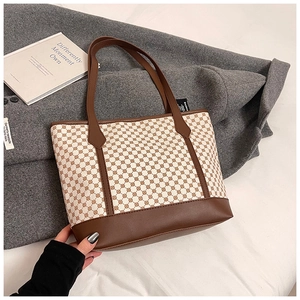Detailed close-up of retro printed tote bag with brown leather handles and geometric patterns