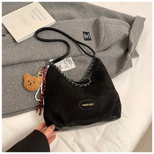 Dettaglio della borsa hobo nera opaca con catena argento e ciondolo a orsetto