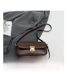 Dettaglio della borsa in ecopelle marrone scuro con chiusura a pressione in metallo dorato