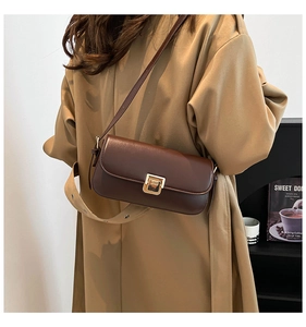 Vista dettagliata di una borsa a tracolla vintage in pelle marrone scuro con un trench alla moda