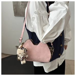 Vue détaillée du sac rose à oreilles de chat avec motif léopard et breloque peluche