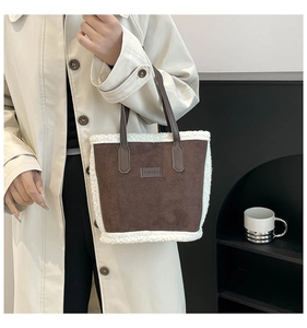 Dettaglio borsa a secchiello in camoscio e shearling con toppa in pelle goffrata