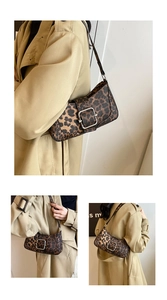 Détail du sac à bandoulière léopard avec une grande boucle en métal argenté sur un manteau