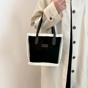 Elegante borsa a mano nera con bordo in shearling bianco e etichetta FASHION