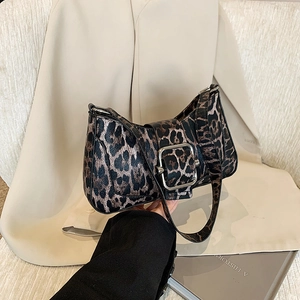 Sac sous le bras chic à motif léopard avec boucle argentée sur fond de costume beige