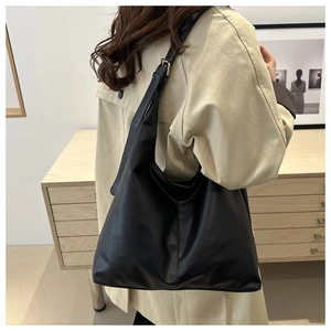 Detail of adjustable strap with silver buckle on large black leather hobo shoulder bag