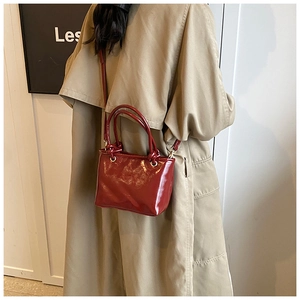Red glossy bucket bag worn with a trench coat for a stylish winter commuting look