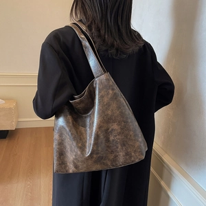 Retro brown oversized tote bag with vintage distressed texture worn by a model