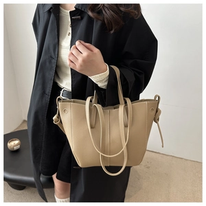 Detailansicht der beigen Tote Bag mit Lychee-Maserung und dekorativen Kordelzug-Knoten