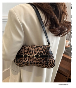 Détail du sac léopard avec boucle dorée et fine bandoulière noire sur le côté