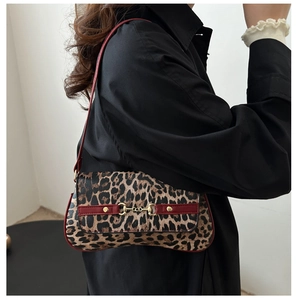 Détail du sac léopard avec garniture en cuir rouge et boucle en métal doré élégante