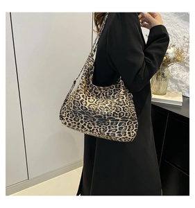 Détail du sac hobo léopard avec large bandoulière noire porté par un mannequin