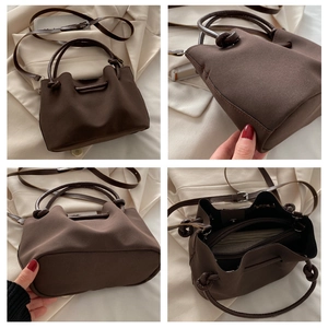 Detailweergave van een vintage bruine canvas handtas met leren handvat en knoopdetail