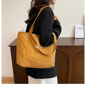 Detail of vintage yellow corduroy tote bag showing ribbed texture and front pocket