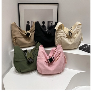 Detailed display of five colorful corduroy crossbody bags arranged on white display steps