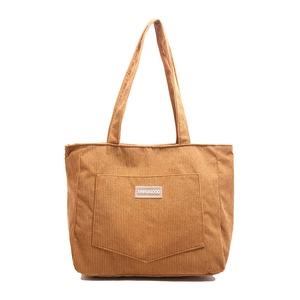 Caramel corduroy tote bag with front pocket and shoulder strap on white background