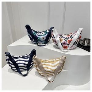 Detail view of four patterned crescent crossbody bags on a minimalist display stand