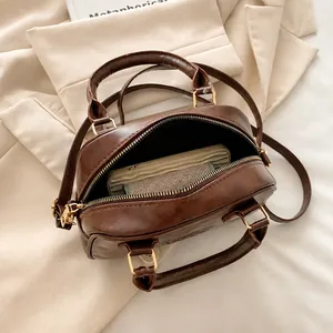 Overhead detail of dark brown Boston bag showing spacious interior and secure zipper closure