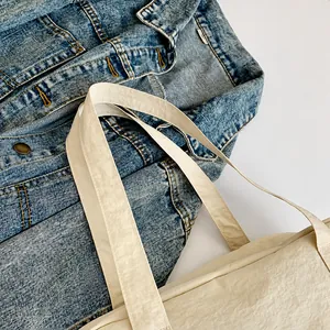 Gros plan détaillé sur la bandoulière large d'un sac de voyage en nylon beige