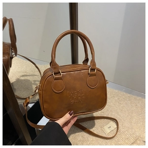 Close-up of vintage brown leather handbag featuring lucky LHCO smu embossed lettering