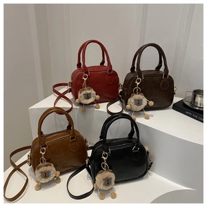 Detail of minimalist leather crossbody bags in four colors with cute plush pendants
