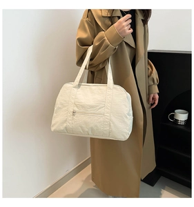 Détail du sac de voyage blanc cassé avec poche zippée et larges anses robustes