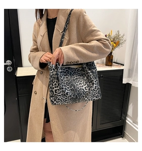 Chic leopard print tote bag styled with a khaki wool coat in a minimalist home setting