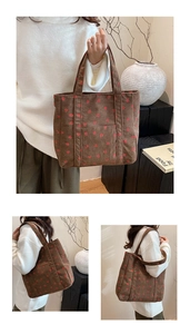 Detail of a brown corduroy tote bag with red strawberry patterns and a front pocket