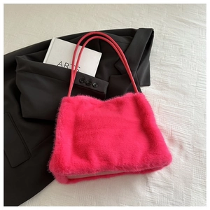 Close-up of rose red faux fur tote bag with long handles on white textured background