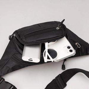 Detail view of large capacity black nylon waist bag showing multiple zipped compartments