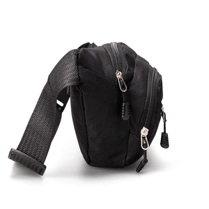 Side view of black nylon chest bag showing multiple zipper compartments and durable strap