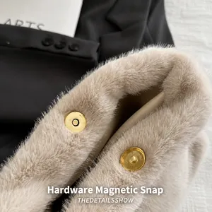 Detail of hardware magnetic snap closures on soft apricot faux fur plush tote bag