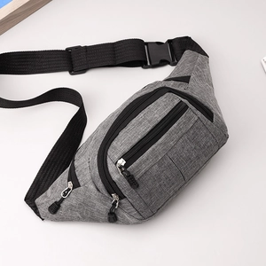 Detail view of the gray fabric texture and three zipper compartments on the cross-body chest bag