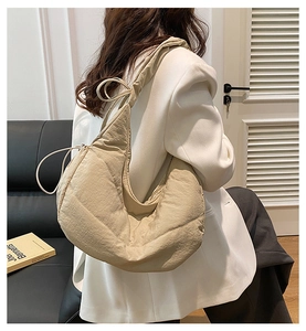 Detalle del bolso acolchado beige con cordón ajustable y textura suave y acolchada