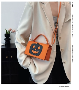 Orange Halloween pumpkin face crossbody bag styled with a white blazer and grey graphic tee