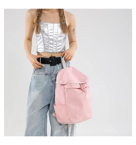 Detalle de mochila de nailon rosa con elegante cremallera de nudo y bolsillo lateral